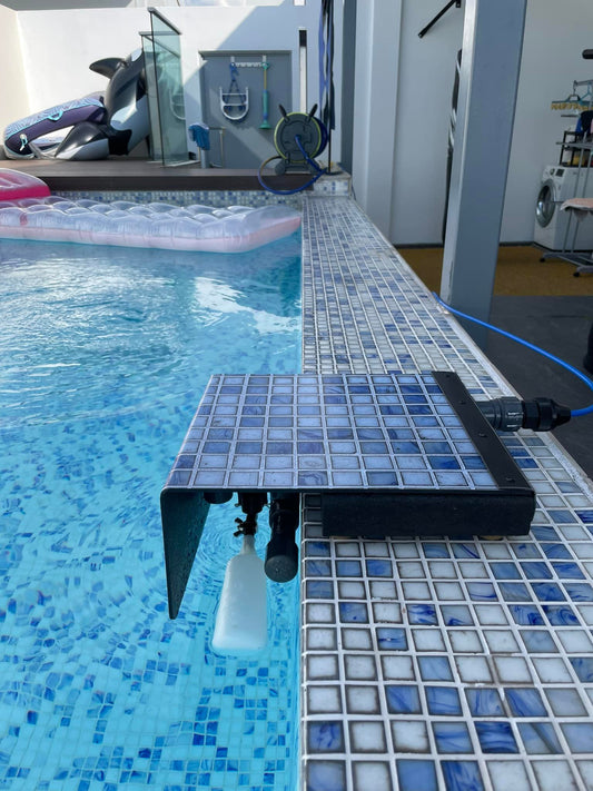 My Pool Filler installed on a tiled in-ground pool edge, showing the float valve in the water and the unit connected to a Hide-A-Hose along the deck.